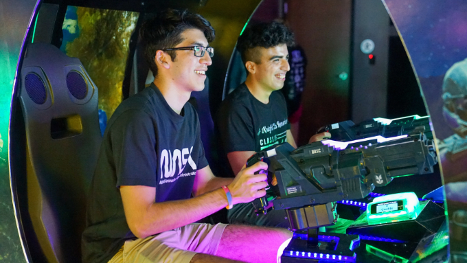 two friends having fun at a santikos entertainment playing the halo arcade game